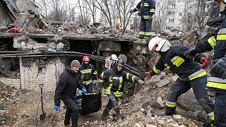Rettungskräfte räumen ein zerbombtes Gebäude in der Ukraine