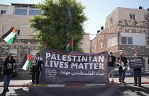 متظاهرون يحملون ملصقات للصحفية الفلسطينية شيرين أبو عاقله في القدس الشرقية. 2022/07/15