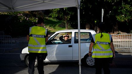 French border police stop a car entering France from Italy at a border crossing in Menton, southern France, Sunday, Nov. 13, 2022.