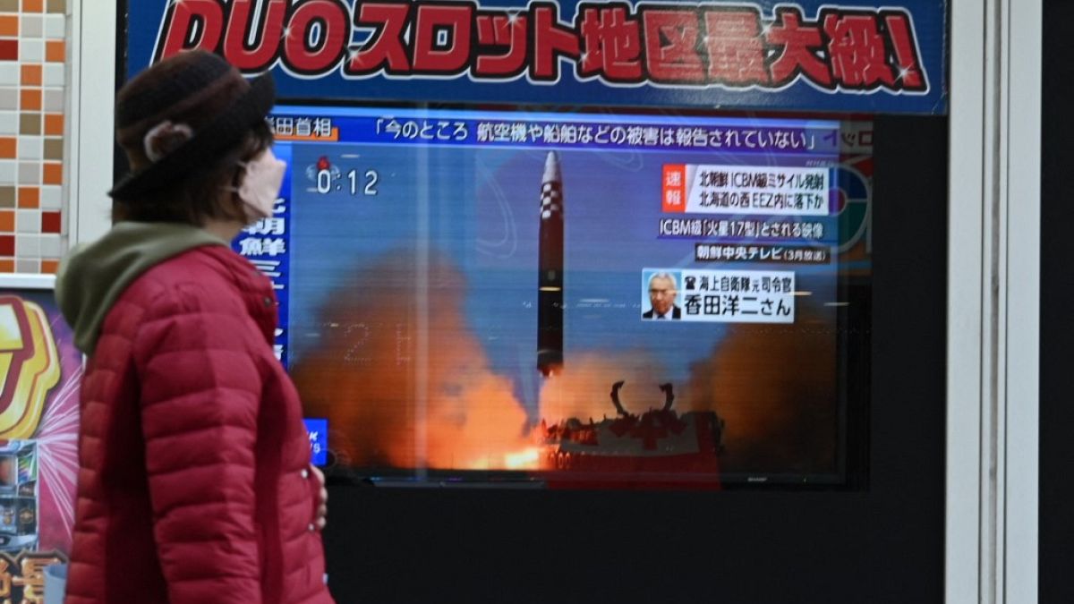 Une femme devant les actualités à Tokyo (Japon), le 18 novembre 2022.
