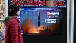 Une femme devant les actualités à Tokyo (Japon), le 18 novembre 2022.