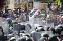 Protesters throw fermented fish sauce to riot police during a protest against the Asia-Pacific Economic Cooperation (APEC) forum, Friday, Nov. 18, 2022, in Bangkok Thailand.