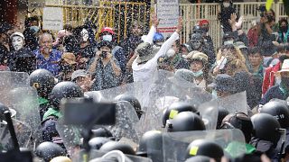 Protesters throw fermented fish sauce to riot police during a protest against the Asia-Pacific Economic Cooperation (APEC) forum, Friday, Nov. 18, 2022, in Bangkok Thailand.