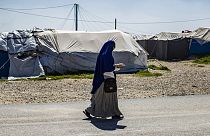 A woman walks through Camp Roj, where relatives of suspected IS supporters are held.