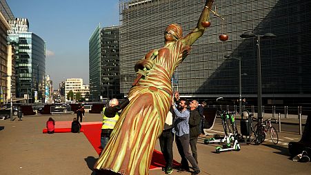 Activists pull down a "Lady Justice" sculpture in front of the European Commission headquarters in Brussels, following an ISDS protest in 2019.