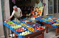 Portekiz'in başkenti Lizbon'da meyve dükkanını açan 67 yaşındaki Alipio Ramos, sattığı ürünlerin fiyatını değiştirirken (arşiv)