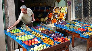 Portekiz'in başkenti Lizbon'da meyve dükkanını açan 67 yaşındaki Alipio Ramos, sattığı ürünlerin fiyatını değiştirirken (arşiv)