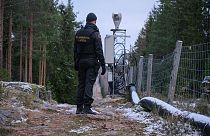 Finnish border guard patrolling fence with Russia