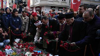Representatives of the Turkish communities put flowers over a memorial placed on the spot of Sunday's explosion on Istanbul's popular pedestrian Istiklal Avenue in Istanbul, T