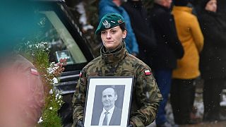 Militar com retrato de uma das vítimas