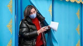 A woman leaves a voting booth to cast her ballot at a polling station in Almaty, Kazakhstan, Sunday, Nov. 20, 2022.