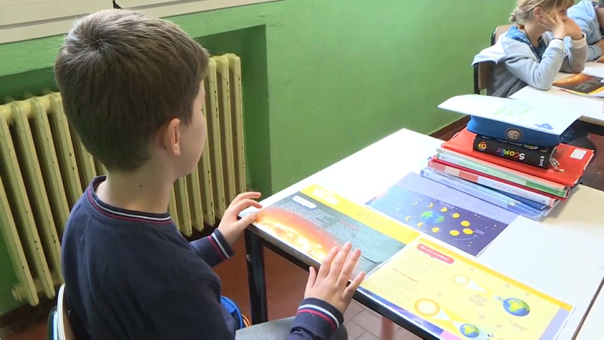 Ukrainian children learn through tri-lingual encyclopedia books in Italian schools