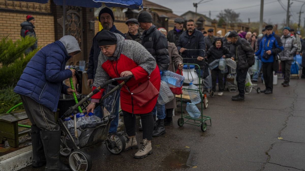 Des habitants font la queue pour remplir des récipients d'eau potable à Kherson, dimanche 20 novembre 2022.