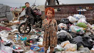 Başkent Kabil'de bir çöp yığınının yanında duran iki çocuk. Afgan çocuklar çöp yığınlarına genellikle yiyecek bir şeyler bulmak için gidiyor
