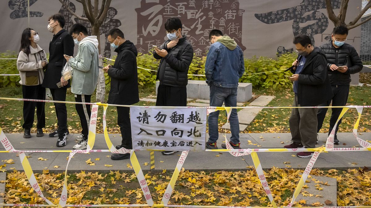 أشخاص يقفون في طابور لإجراء اختبارات COVID-19 في موقع اختبار فيروس كورونا في بكين. 