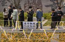 أشخاص يقفون في طابور لإجراء اختبارات COVID-19 في موقع اختبار فيروس كورونا في بكين. 