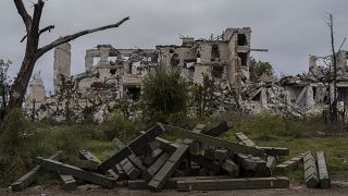 Des boîtes de munitions à l'extérieur d'une école détruite dans un village récemment libéré à la périphérie de Kherson, dans le sud de l'Ukraine