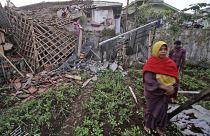 A woman walks past a house damaged by an earthquake in Cianjur, West Java, Indonesia, Monday, Nov. 21, 2022.