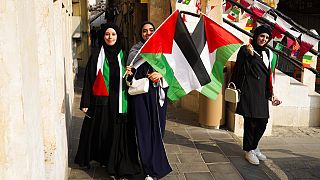 نساء فلسطينيات يلوحن بالعلم الفلسطيني قبل انطلاق كأس العالم لكرة القدم في الدوحة، قطر، السبت 19 نوفمبر 2022