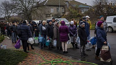 Residents queue to fill containers with drinking water in Kherson, southern Ukraine, Thursday, Nov. 24, 2022.
