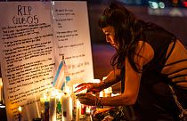 A mourner pays their respects at a makeshift memorial for the victims of the mass shooting at Club Q.
