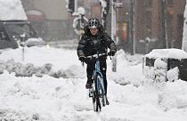 الصورة لمواطن يتنقل بواسطة دراجة هوائية وسط الثلوج في السويد 