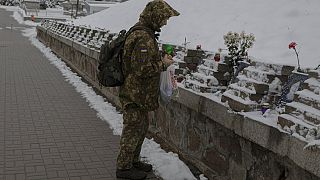 Militar acende vela na Praça da Independência, em Kiev