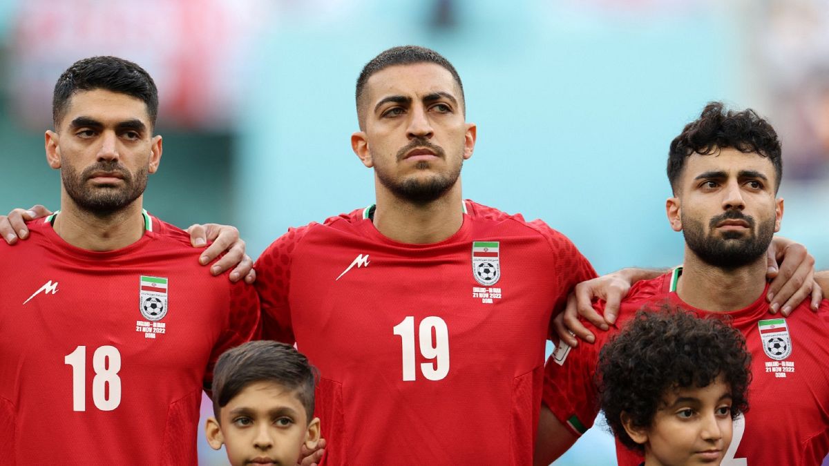 Iran's midfielder #18 Ali Karimi, Iran's defender #19 Majid Hosseini and Iran's defender #02 Sadegh Moharrami listen to the national anthem