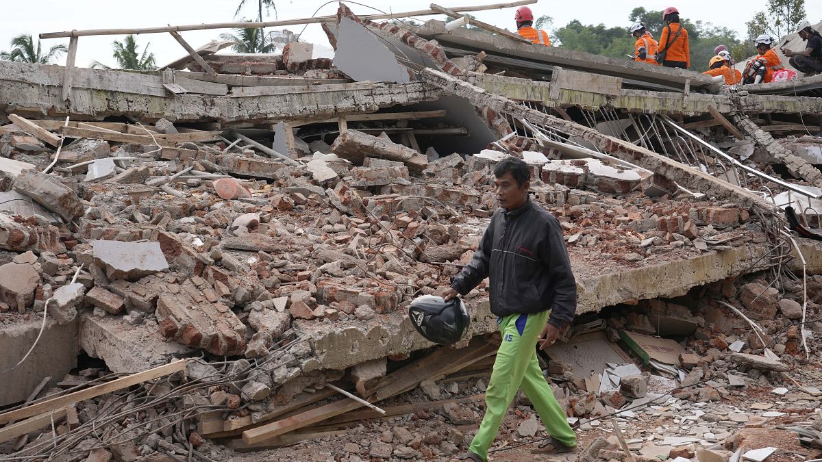 Un homme récupère les effets personnels d'une maison endommagée par le tremblement de terre de lundi à Cianjur, Indonésie