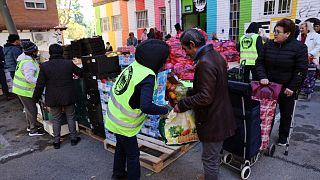 A man gets food from a volunteer of Aluche neighbourhood association in Madrid on November 19, 2022.