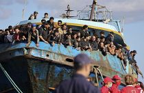 Migranten schauen aus einem Fischerboot, das im Hafen von Palaiochora im Südosten Kretas angedockt hat. 22. 11. 2022