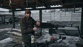 A Ukrainian soldier stands near a machine gun near Liman, Donetsk region