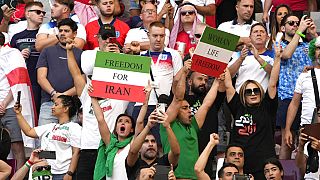 Iranian soccer fans hold up signs reading Woman Life Freedom and Freedom For Iran, at the Khalifa International Stadium in in Doha, Qatar, Monday, Nov. 21, 2022.