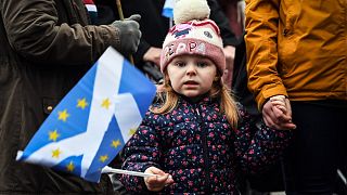 A young pro-independence protester holds a Saltire (Scottish flag) during a March against Boris Johnson in Glasgow on January 22, 2022