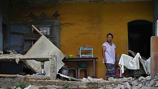 امرأة تقف بجوار حائط من الطوب انهار في منزلها بعد زلزال عنيف ضرب جزيرة جاوا الإندونيسية