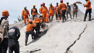 Rescuers cut through the rubble of a collapsed building in Cianjur, West Java