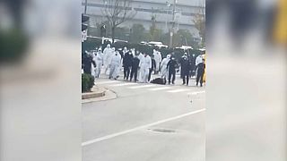 Videos on Chinese social media appeared to show thousands of people in masks facing rows of police in white protective suits with plastic riot shields