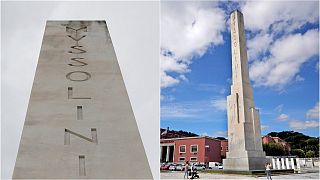 A marble obelisk with engravings reading 'Mussolini Dux' is located in front of Rome's Olympic Stadium.