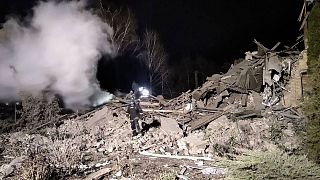 آتش‌نشان اوکراینی روی ویرانه‌های یک بیمارستان زایشگاهی کوچک در ویلنیانسک که بر اثر حملات روسیه ویران شد