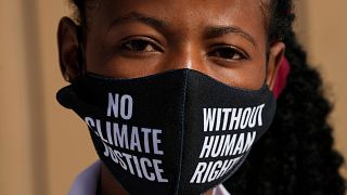 A woman wears a face mask that reads "no climate justice without human rights" during a silent protest for climate justice and human rights at COP27.