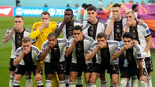 Les joueurs de football allemands se cachent la bouche symboliquement lors de la photo d'avant match 