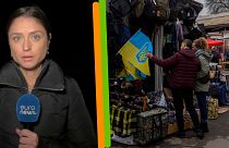 A g. : Anelise Borges (d'euronews) à Odessa, le 23/11/2022 - A dr. : devant un vendeur de drapeaux ukrainiens à Kherson, le 23/11/2022