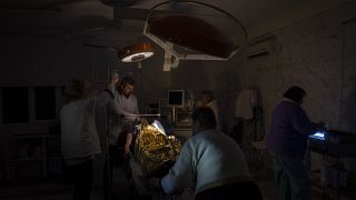 Des médecins opèrent un garçon de 13 ans blessé lors d'un bombardement dans un hôpital plongé dans le noir ou presque et avec très peu d'eau à Kherson, le 22 novembre 2022