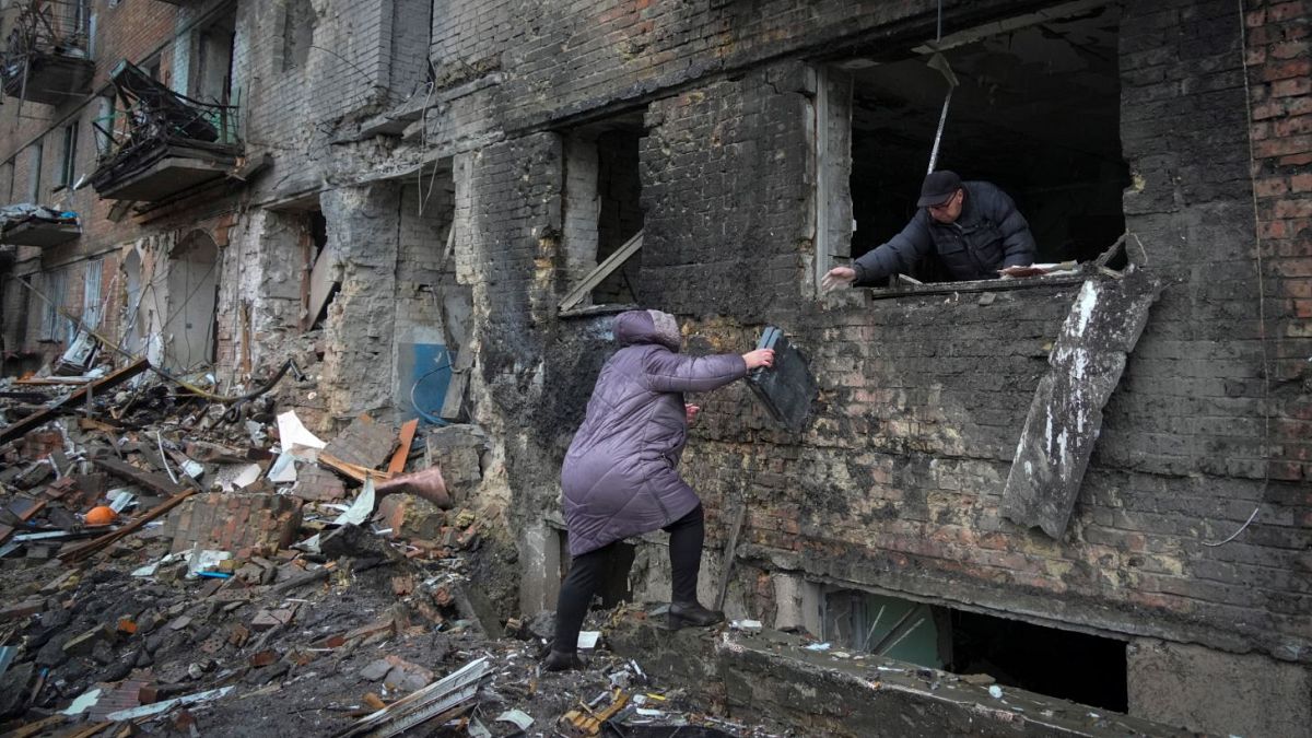 People gather their belongings from a damaged house in the town of Vyshgorod.