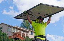 Phil Snow, of Power Shift Solar, installs a solar panel at a home in Salt Lake City.