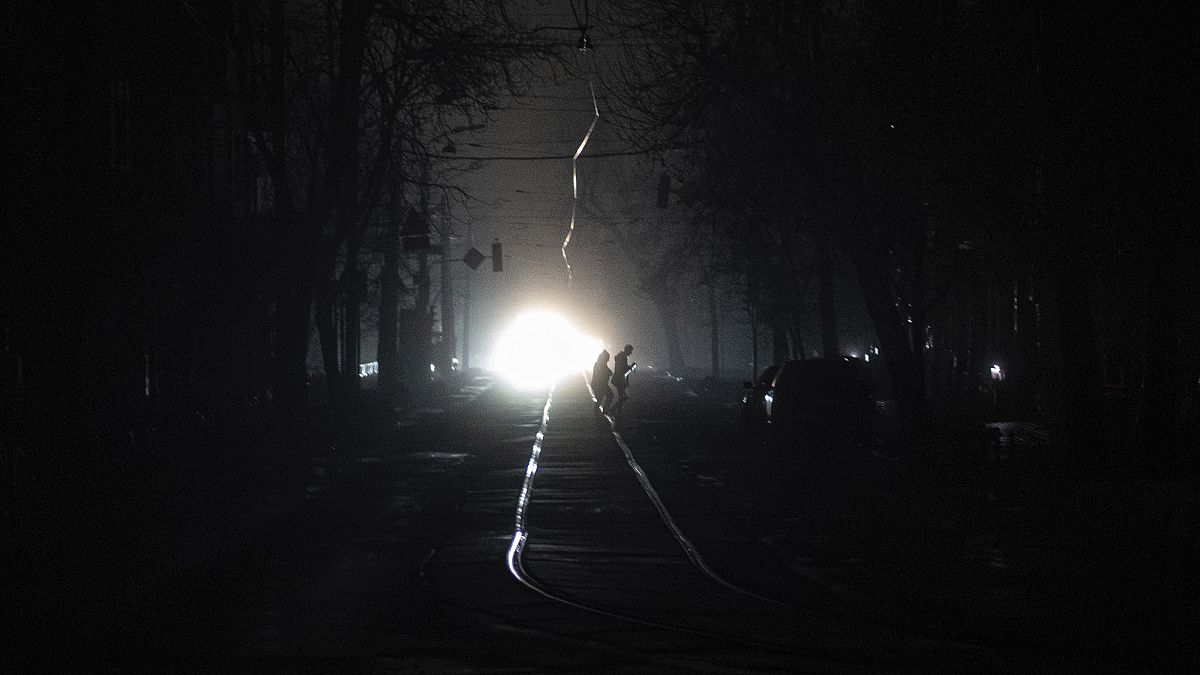 People cross the road at the city center which lost electrical power after a Russian rocket attack in Kyiv