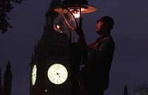 Paul Doy lights a gas-powered streetlamp outside London's Westminster Abbey.