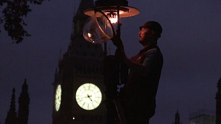 Paul Doy lights a gas-powered streetlamp outside London's Westminster Abbey.