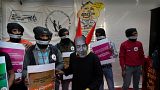 A woman dressed as Jeff Bezos, Executive Chairman of Amazon, and other Gig Workers Association (GigWA) and Amazon Warehouse workers participate in a protest in New Delhi. 