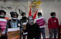 A woman dressed as Jeff Bezos, Executive Chairman of Amazon, and other Gig Workers Association (GigWA) and Amazon Warehouse workers participate in a protest in New Delhi.